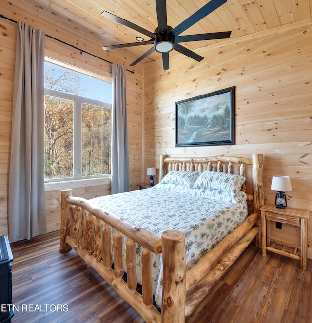 bedroom with wood walls, lofted ceiling, dark wood-type flooring, ceiling fan, and wood ceiling