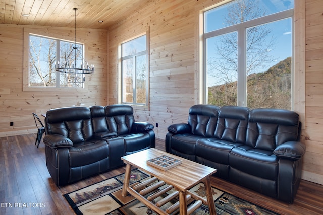 living room with wooden walls, dark hardwood / wood-style floors, a wealth of natural light, and vaulted ceiling