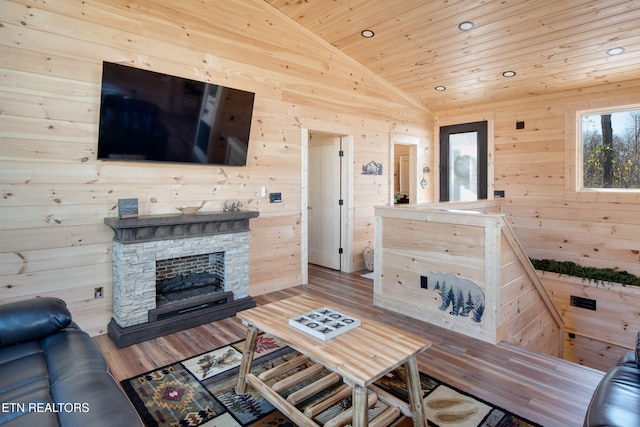 living room featuring light wood-type flooring, wood ceiling, wooden walls, a fireplace, and lofted ceiling