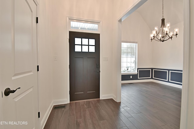 entryway featuring vaulted ceiling, dark hardwood / wood-style flooring, and a chandelier