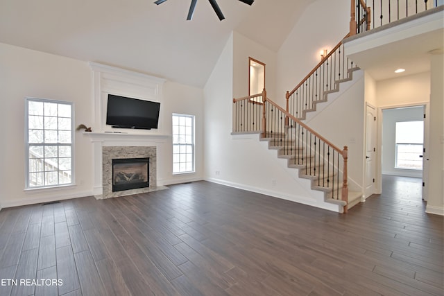 unfurnished living room featuring a fireplace, high vaulted ceiling, and dark hardwood / wood-style floors