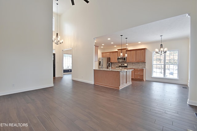 kitchen with dark hardwood / wood-style flooring, a wealth of natural light, hanging light fixtures, and stainless steel appliances