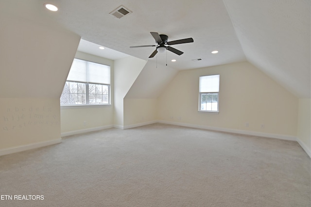 additional living space with light colored carpet, ceiling fan, and lofted ceiling