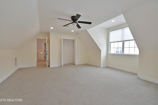 additional living space featuring ceiling fan, light colored carpet, and vaulted ceiling