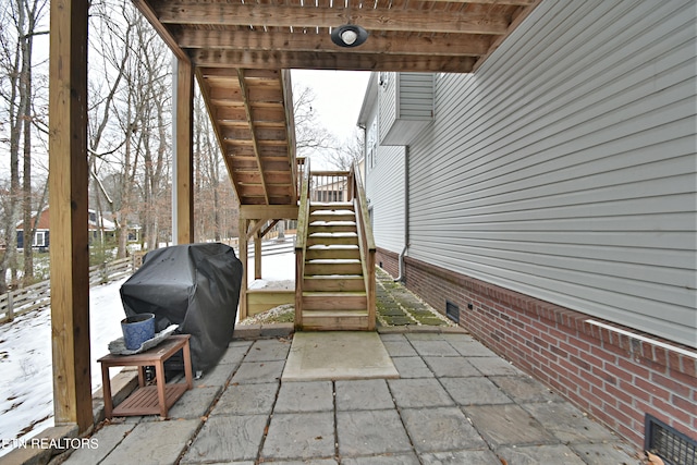 snow covered patio with a grill