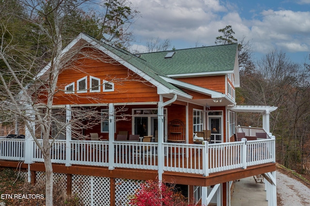 rear view of house featuring a wooden deck