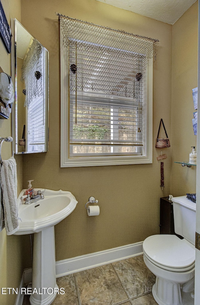 bathroom featuring tile patterned floors, a textured ceiling, and toilet