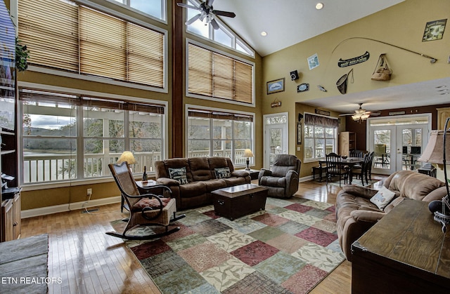 living room featuring french doors, light hardwood / wood-style floors, high vaulted ceiling, and ceiling fan