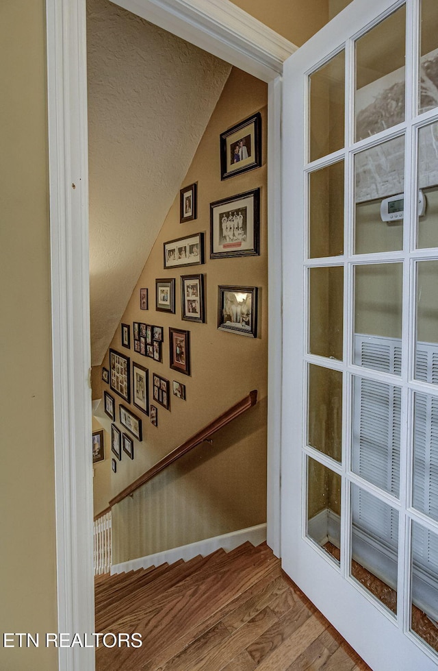 stairway with hardwood / wood-style flooring and vaulted ceiling