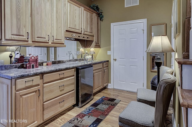 kitchen featuring light brown cabinets, light hardwood / wood-style floors, wine cooler, and sink