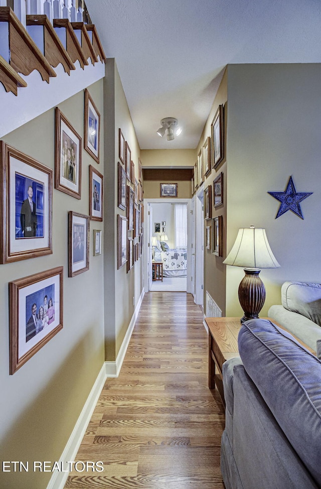 hallway with light hardwood / wood-style floors