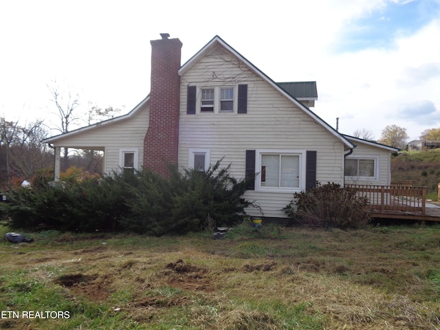 rear view of property featuring a wooden deck