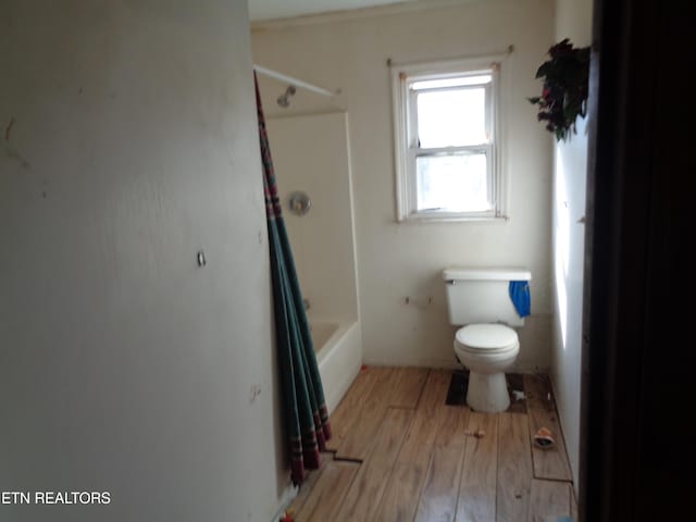 bathroom featuring shower / bathing tub combination, wood-type flooring, and toilet