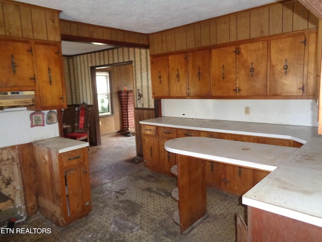 kitchen featuring wood walls and a textured ceiling