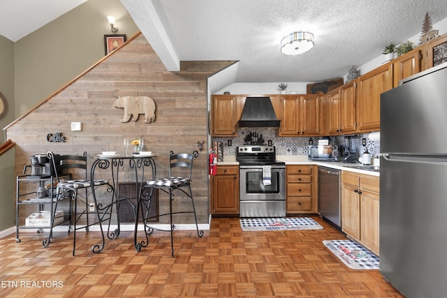 kitchen featuring custom exhaust hood, light parquet floors, wooden walls, decorative backsplash, and stainless steel appliances