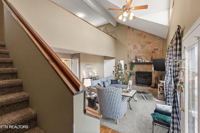 living room featuring ceiling fan, beam ceiling, high vaulted ceiling, light hardwood / wood-style flooring, and a fireplace