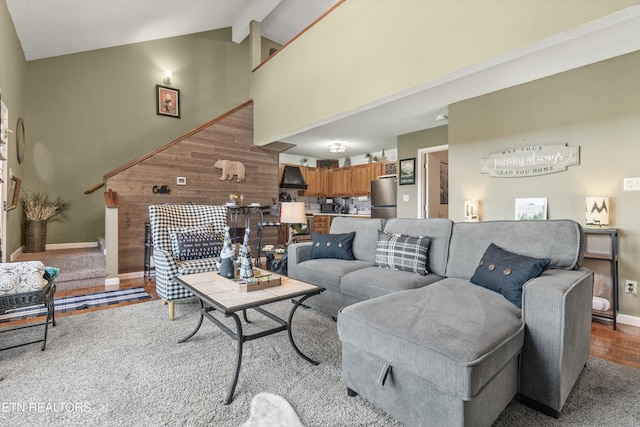 living room featuring beamed ceiling, wood-type flooring, and high vaulted ceiling