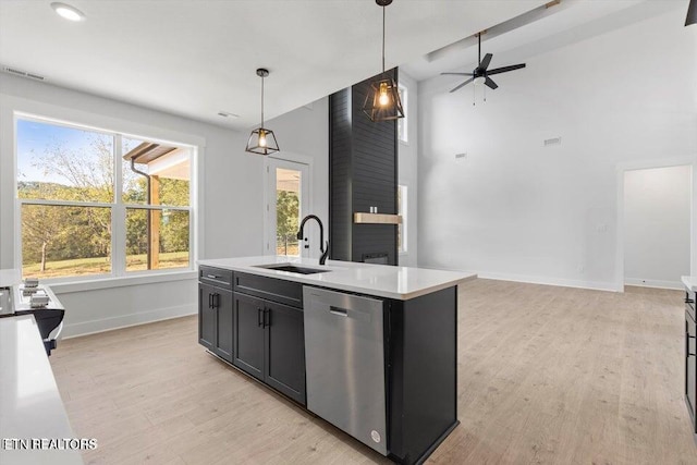 kitchen featuring dishwasher, a center island with sink, light hardwood / wood-style floors, and decorative light fixtures