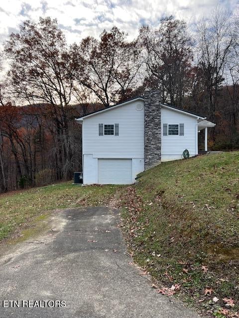 view of outbuilding featuring central air condition unit and a lawn