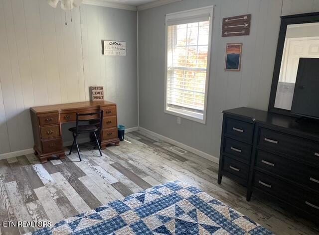 office featuring ceiling fan, light wood-type flooring, crown molding, and wooden walls