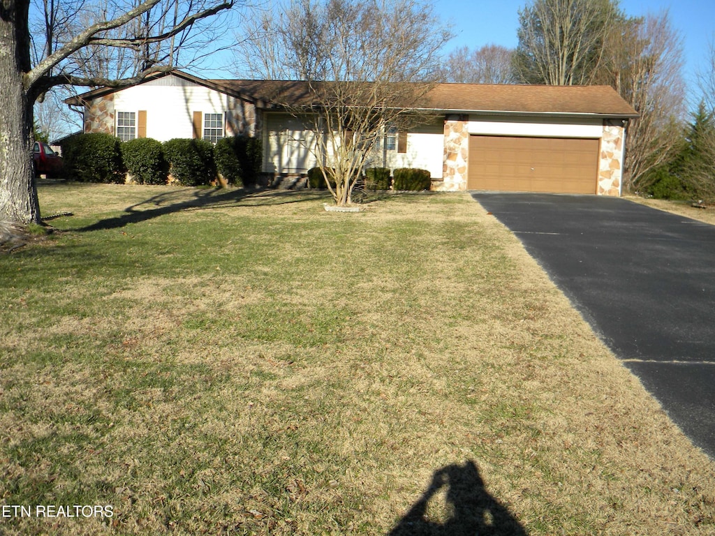 ranch-style home featuring a front lawn and a garage