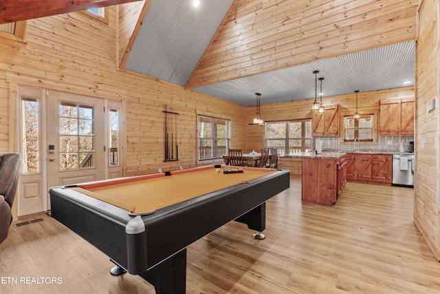 recreation room with light hardwood / wood-style floors, high vaulted ceiling, pool table, and wood walls