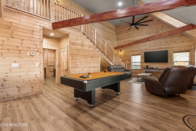 recreation room featuring beamed ceiling, high vaulted ceiling, light hardwood / wood-style flooring, and wooden walls