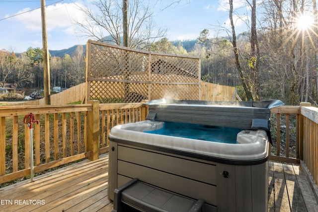 wooden deck featuring a mountain view and a hot tub