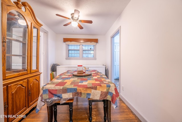 dining space featuring a textured ceiling, ceiling fan, and dark hardwood / wood-style floors