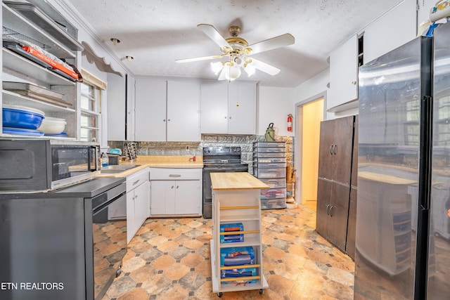 kitchen with butcher block counters, ceiling fan, stainless steel appliances, a textured ceiling, and white cabinets