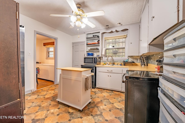 kitchen with sink, ceiling fan, range with electric stovetop, tasteful backsplash, and white cabinetry