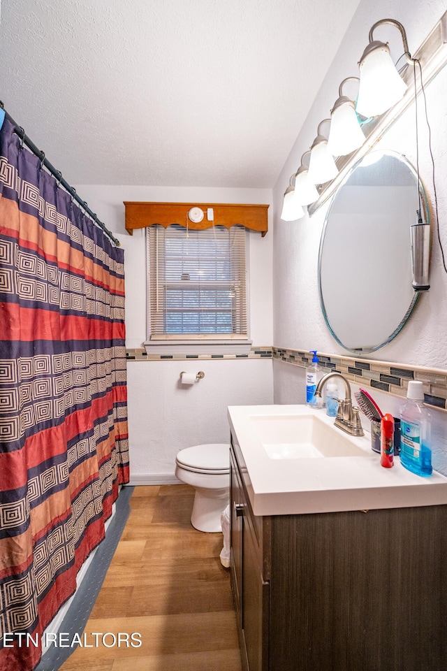 bathroom with wood-type flooring, vanity, a textured ceiling, and toilet