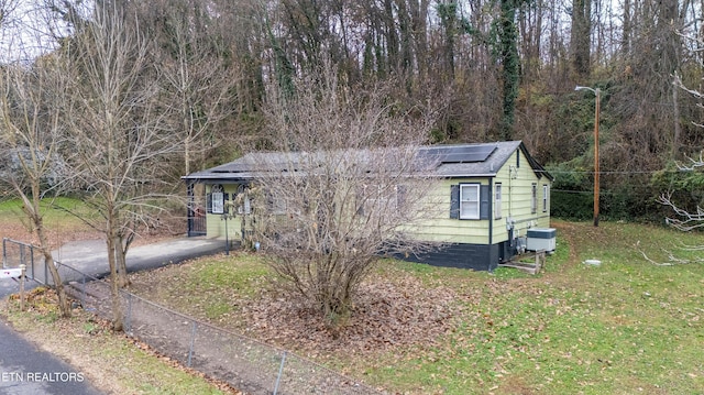 view of front of house featuring a front lawn and solar panels