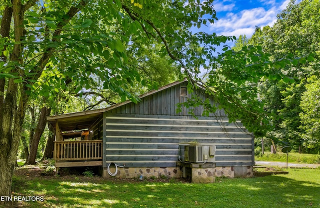 view of side of home with cooling unit and a lawn