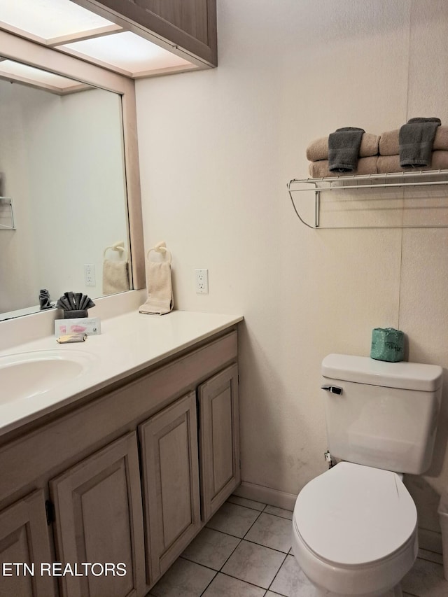 bathroom with tile patterned flooring, vanity, and toilet