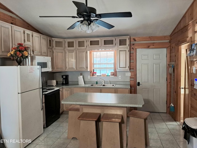 kitchen with vaulted ceiling, white appliances, a kitchen bar, wooden walls, and a kitchen island