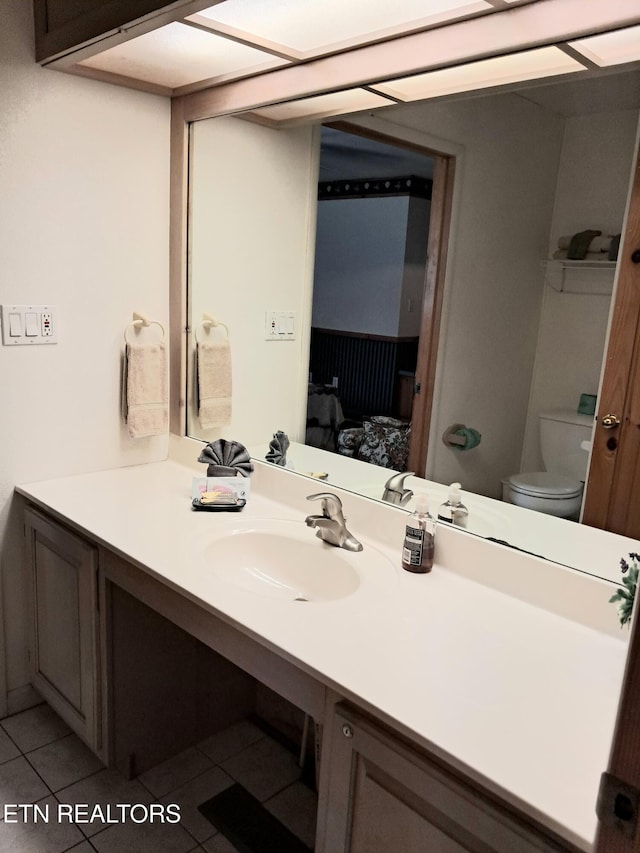 bathroom with tile patterned flooring, vanity, and toilet