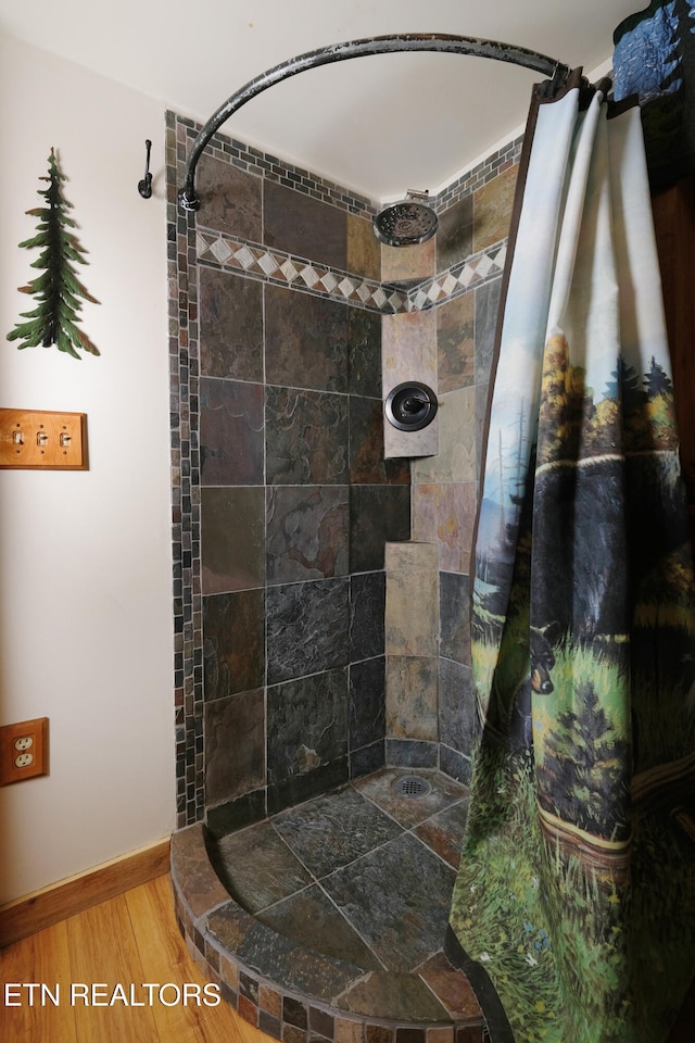 bathroom with hardwood / wood-style flooring and curtained shower