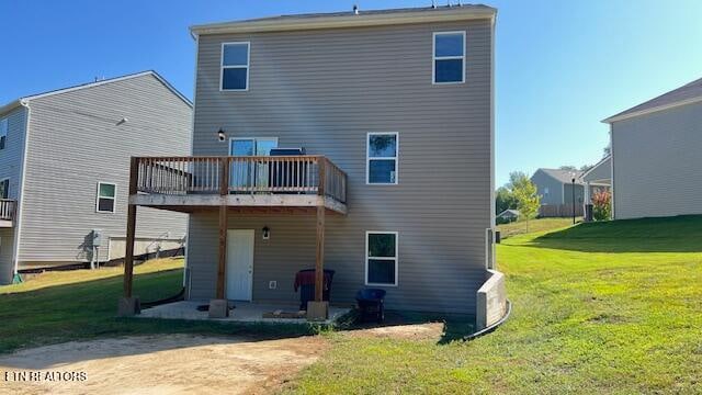 rear view of house with a lawn, a patio area, and a deck