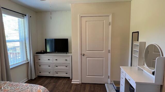 bedroom with dark wood-type flooring