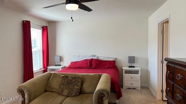 carpeted bedroom featuring multiple windows and ceiling fan