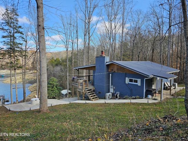 view of property exterior with a yard and a water view