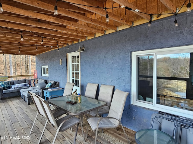 wooden terrace with an outdoor living space