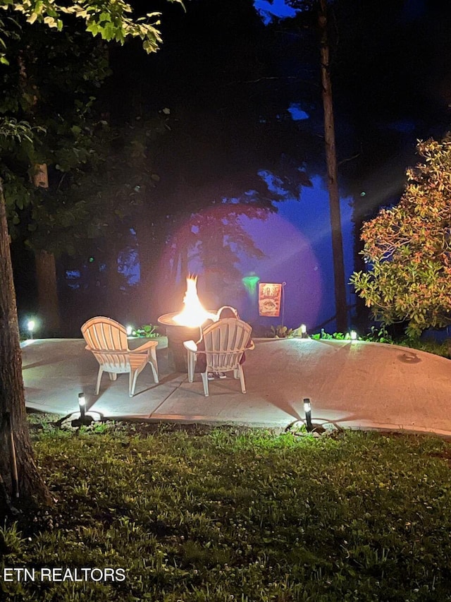 yard at night featuring a patio area