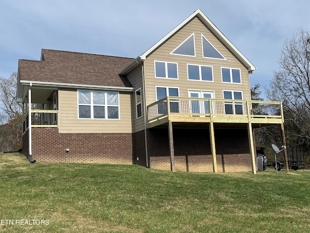 rear view of house featuring a lawn and a wooden deck