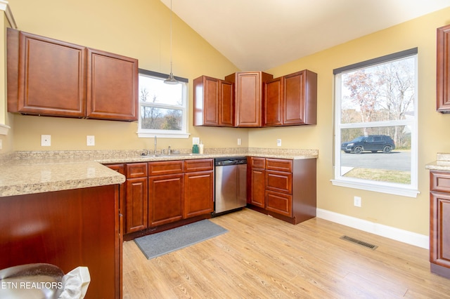 kitchen with a wealth of natural light, stainless steel dishwasher, pendant lighting, lofted ceiling, and light wood-type flooring