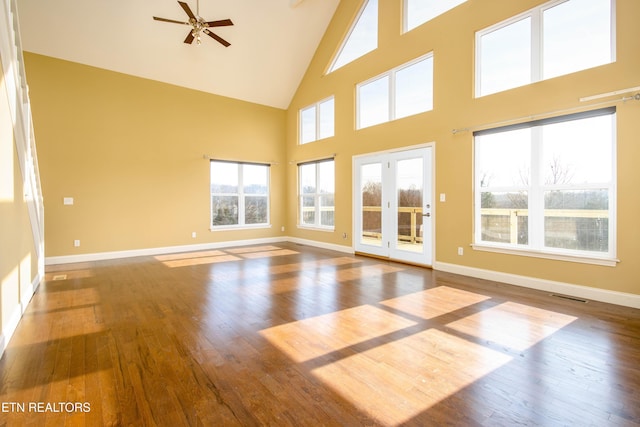 unfurnished room featuring hardwood / wood-style flooring, high vaulted ceiling, and plenty of natural light