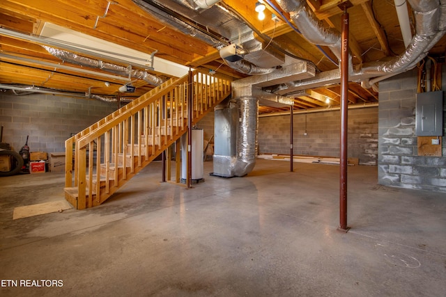 basement featuring electric panel and water heater