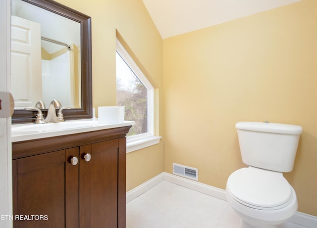 bathroom with vanity, toilet, and vaulted ceiling