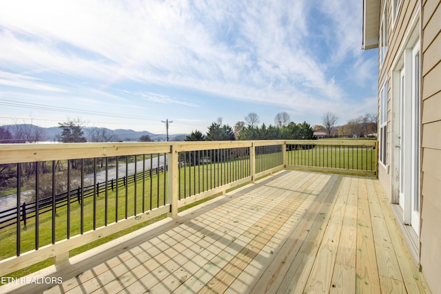 wooden deck featuring a lawn